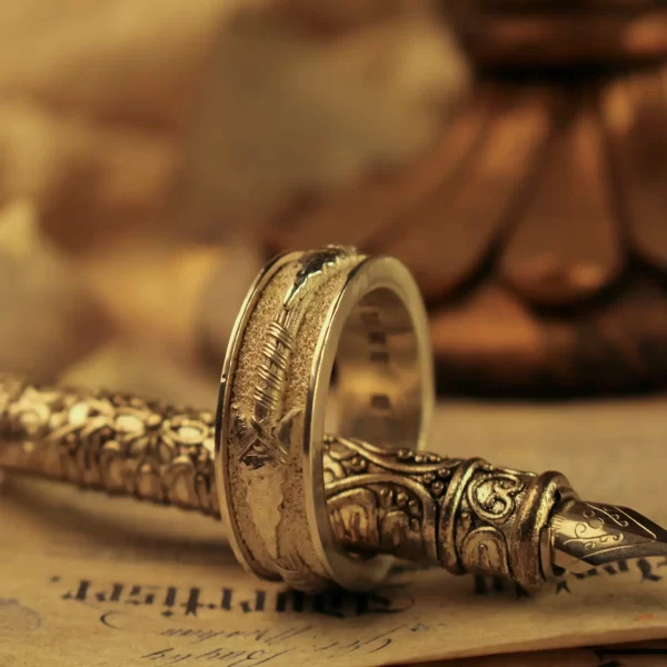 Introducing the exquisite Silveringdom Matching Rings, a perfect symbol of unity and love. These rings, crafted in light silver, feature intricate engravings that catch the light beautifully. The design includes a delicate arrow motif, symbolizing direction and purpose, making these rings not just accessories but meaningful tokens of commitment. The rings are displayed elegantly, one standing upright encircling the other, highlighting their connection. Set against a backdrop of cursive handwriting and a vintage silver pen, the image evokes a sense of timeless romance and partnership. Ideal for weddings or anniversaries, these matching rings from Silveringdom are a testament to enduring love and shared journeys.