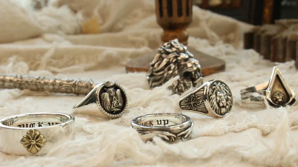 This image showcases an elegant collection of handcrafted silver rings, highlighting the artistry and timeless appeal of Silveringdom. Designed with versatility and inclusivity in mind, the collection features gender-neutral matching rings in intricate styles that symbolize unity and individuality. Each piece reflects Silveringdom’s dedication to meticulous craftsmanship and meaningful design, with elements that evoke strength, elegance, and connection. From bold signet rings to delicate, polished bands, the pieces blend light and dark tones, embodying the brand’s philosophy of duality and harmony. Perfect for celebrating love, friendship, or self-expression, these rings are a testament to Silveringdom’s mission of creating jewelry that transcends boundaries while offering long-lasting beauty and significance.