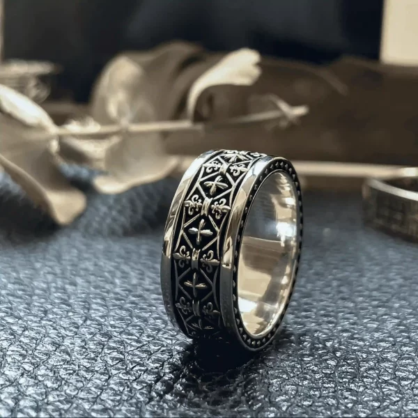 In the enchanting world of Silveringdom, these matching rings tell a story of elegance and valor. Crafted from dark silver, each ring features intricate designs that evoke the spirit of a noble knight. The prominent ring showcases a detailed pattern, reminiscent of ancient armor, symbolizing strength and honor. Its companion, slightly blurred in the background, suggests a harmonious pair, perfect for those who cherish unity and shared journeys. The soft-focus backdrop hints at the presence of Iris, the messenger goddess, adding a touch of myth and mystery. These rings are more than just jewelry; they are tokens of timeless tales and enduring bonds, crafted with precision and passion by Silveringdom.