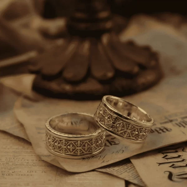 Introducing the Silveringdom Matching Rings – a stunning pair of light silver rings that embody elegance and timeless romance. These rings feature intricate designs inspired by the iris flower, symbolizing faith and wisdom. Each ring is meticulously crafted to reflect the noble spirit of a knight, making them perfect for couples who cherish chivalry and devotion. The delicate patterns and the luminous silver finish create a harmonious blend of beauty and strength. Whether exchanged as a promise, engagement, or wedding rings, the Silveringdom Matching Rings are a testament to enduring love and commitment. Embrace the legacy of the past with these exquisite pieces that tell a story of honor and everlasting bond.