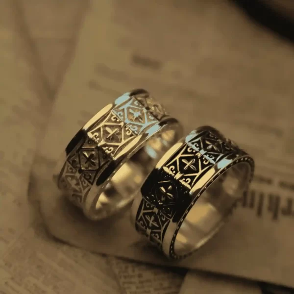 In the enchanting realm of Silveringdom, these matching rings stand as symbols of unity and elegance. The first ring, crafted in light silver, showcases intricate patterns reminiscent of a noble knight’s armor, reflecting a soft, ethereal glow. Its counterpart, in dark silver, mirrors the same exquisite design, absorbing light to create a striking contrast. Both rings feature a central iris motif, symbolizing vigilance and protection. Together, they tell a story of timeless bonds and shared journeys, perfect for those who seek a blend of tradition and modernity in their jewelry. These rings are not just accessories but heirlooms, capturing the essence of Silveringdom’s craftsmanship and artistry.