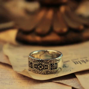 Introducing the exquisite Silveringdom Matching Rings, crafted from dark silver to exude a timeless elegance. Each ring features a prominent cross design, symbolizing unity and faith. The intricate patterns surrounding the cross add a touch of sophistication, making these rings perfect for couples who appreciate both style and meaning. The dark silver material gives the rings a luxurious and antique appearance, ideal for those who cherish unique and regal jewelry. Whether as a symbol of commitment or a stylish accessory, these matching rings from Silveringdom are sure to captivate and inspire. Embrace the elegance and significance of these beautifully crafted rings, designed to stand the test of time.