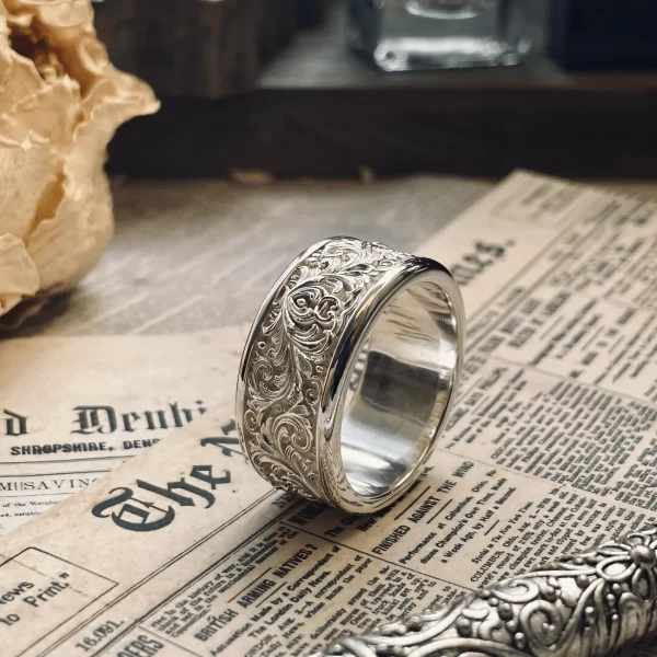 These matching rings from Silveringdom feature intricate scrollwork in beautiful relief on light silver bands. The detailed craftsmanship of the scrollwork stands out, creating a raised, three-dimensional effect that adds depth and texture to the rings. The light silver hue enhances their elegance, making them perfect for any special occasion. The scrollwork design, with its delicate and ornate patterns, gives the rings a vintage charm that is both timeless and sophisticated. These matching rings are not just accessories but symbols of a unique bond, crafted to be cherished forever. The artistry and attention to detail in these rings make them a standout piece in any jewelry collection.