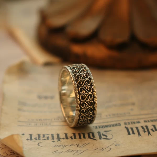 In the heart of Silveringdom, a realm where timeless elegance meets modern craftsmanship, lies a collection of vintage vow engagement rings. This image showcases a stunning piece, meticulously handcrafted to perfection. The ring, with its dark silver band, exudes a unique charm that appeals to both traditional and androgynous tastes. Each ring is a testament to the art of customization, allowing couples to create a symbol of their love that is as unique as their bond. The intricate details and the deep, rich hue of the dark silver make these engagement rings stand out, offering a perfect blend of vintage allure and contemporary style. Whether you seek a classic design or a modern twist, Silveringdom’s engagement rings promise to capture the essence of your love story with unparalleled craftsmanship and personalized elegance.