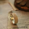 The image showcases a stunning wedding ring from Silveringdom, embodying the essence of a vintage vow. This handcrafted piece, made from light silver, exudes timeless elegance and meticulous craftsmanship. The intricate detailing on the ring highlights the brand’s dedication to creating unique, customizable jewelry. Designed to be gender-neutral, this wedding ring appeals to a wide range of tastes and preferences, making it a perfect symbol of love and commitment for any couple. The ability to customize the ring ensures that each piece is as unique as the love story it represents. Silveringdom’s commitment to quality and individuality shines through in this exquisite example of their work.